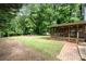 Expansive backyard featuring a screened-in porch, brick walkway, and fire pit area at 5625 Linda Vista Ln, Charlotte, NC 28216