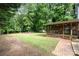 Expansive backyard featuring a screened-in porch, brick walkway, and fire pit area at 5625 Linda Vista Ln, Charlotte, NC 28216