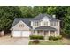 Attractive two-story brick home with a covered front porch, attached two-car garage, and mature landscaping at 5625 Linda Vista Ln, Charlotte, NC 28216