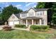 Charming two-story brick home featuring a well-manicured lawn, inviting front porch, and attached two-car garage at 5625 Linda Vista Ln, Charlotte, NC 28216