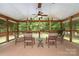 Enjoy the outdoors in this screened in porch featuring a ceiling fan, comfortable seating and a nature view at 5625 Linda Vista Ln, Charlotte, NC 28216