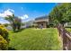 A meticulously maintained backyard with lush green grass, mature trees, and a charming pergola covered patio at 6107 Raisin Tree Ln, Charlotte, NC 28215