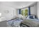 Well-lit bedroom with white walls, blue accents, and a cozy bed at 6107 Raisin Tree Ln, Charlotte, NC 28215