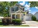 A cozy two-story home with neat landscaping, a covered front porch, and an attached two-car garage at 6107 Raisin Tree Ln, Charlotte, NC 28215