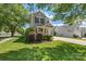 Well-kept home featuring manicured lawn, mature bushes, a covered front porch, and a driveway leading to the garage at 6107 Raisin Tree Ln, Charlotte, NC 28215