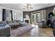 Bright living room featuring a fireplace, gray sofa, and French doors leading outside at 6107 Raisin Tree Ln, Charlotte, NC 28215