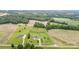 Aerial view displaying two properties with manicured lawns, surrounded by a mix of fields and wooded areas at 6201 New Hope Church Rd, Marshville, NC 28103