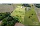 Expansive aerial view of the property featuring lush green landscape, wooded areas, and neighboring homes at 6201 New Hope Church Rd, Marshville, NC 28103