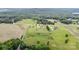 Aerial view showcases the property's location amidst trees, fields, and neighboring homes in a serene setting at 6201 New Hope Church Rd, Marshville, NC 28103