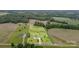 Expansive aerial view of a property showcasing the house, large lot, and surrounding landscape with wooded area at 6201 New Hope Church Rd, Marshville, NC 28103