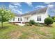 Exterior showcasing a white house with a patio, surrounded by landscaping, grass, and blue sky at 6201 New Hope Church Rd, Marshville, NC 28103