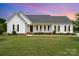 Charming single-story home featuring a covered front porch, manicured lawn, and classic architectural details at 6201 New Hope Church Rd, Marshville, NC 28103