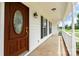 Close-up of a charming front porch with a decorative front door, white columns, and well-maintained landscaping at 6201 New Hope Church Rd, Marshville, NC 28103