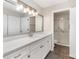 Bright bathroom with a long vanity, quartz countertop, and sliding glass shower doors at 7026 Quail Hill Rd, Charlotte, NC 28210