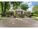 Traditional brick home with symmetrical design, landscaped yard, and welcoming front entrance at 7026 Quail Hill Rd, Charlotte, NC 28210