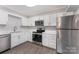 Updated kitchen with stainless steel appliances, white cabinets, and modern backsplash at 7026 Quail Hill Rd, Charlotte, NC 28210