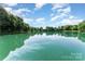 Picturesque view of the pond with tree-lined borders and clear blue sky reflected in the water at 7026 Quail Hill Rd, Charlotte, NC 28210