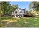 Back exterior with deck and stairs leading to yard with grass and trees at 800 Woodlawn St, Belmont, NC 28012