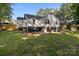 Back exterior with deck and stairs leading to yard with grass and trees at 800 Woodlawn St, Belmont, NC 28012