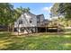 Back exterior with deck and stairs leading to yard with grass and trees at 800 Woodlawn St, Belmont, NC 28012
