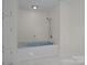 Bright bathroom with a built-in tub, shower fixture, and matching white storage cabinets at 800 Woodlawn St, Belmont, NC 28012