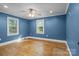 Empty bedroom with hardwood floors, ceiling fan and two windows at 800 Woodlawn St, Belmont, NC 28012