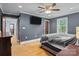 Spacious bedroom with hardwood floors, ceiling fan and flat screen television at 800 Woodlawn St, Belmont, NC 28012
