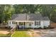 Charming one-story home with a landscaped front yard, a porch swing, and a fenced yard at 800 Woodlawn St, Belmont, NC 28012