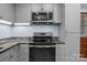 Stylish kitchen with stainless steel microwave, granite countertops and gray cabinets at 800 Woodlawn St, Belmont, NC 28012