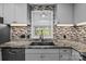 Granite countertops and tile backsplash highlight the kitchen's sink and window at 800 Woodlawn St, Belmont, NC 28012