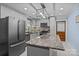 Well-lit kitchen featuring stainless steel appliances, granite countertops, tile backsplash, and center island at 800 Woodlawn St, Belmont, NC 28012