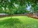 A spacious, well-maintained backyard with lush green grass, a wooden fence, and a wooden deck at 827 Fairbanks Rd, Charlotte, NC 28210