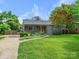 Charming home with lush landscaping, driveway, and a welcoming front yard with mature trees at 827 Fairbanks Rd, Charlotte, NC 28210