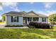 A charming single-story home with a quaint front porch, flowers and well-manicured lawn at 835 Jet St, Kannapolis, NC 28081