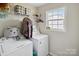 Laundry room features white appliances, wire shelving, and a window for natural light at 835 Jet St, Kannapolis, NC 28081