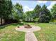 Lush backyard showcasing a fire pit with a circular gravel area and brick pathway at 8605 Soaring Eagle Ln, Waxhaw, NC 28173