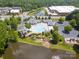 Aerial view of a community pool, clubhouse, and recreational amenities near a pond at 8605 Soaring Eagle Ln, Waxhaw, NC 28173