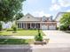 Charming brick home with a manicured lawn, dormer windows, a two-car garage, and a welcoming front porch at 8605 Soaring Eagle Ln, Waxhaw, NC 28173