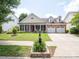 Charming brick home with a manicured front lawn, inviting entrance, and attached two car garage at 8605 Soaring Eagle Ln, Waxhaw, NC 28173