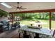 Relaxing covered patio featuring comfortable seating, a dining table, and a tranquil view of the backyard at 8605 Soaring Eagle Ln, Waxhaw, NC 28173