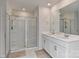 The bathroom features a double vanity with bright lighting, modern fixtures, and a glass enclosed shower at 9505 Cotswood Pl, Gastonia, NC 28056