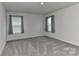 A bright bedroom provides relaxing comfort with two windows and a neutral carpet flooring at 9505 Cotswood Pl, Gastonia, NC 28056