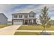 Charming two-story home boasting stone accents, gray siding, a well-manicured lawn, and a two car garage at 9505 Cotswood Pl, Gastonia, NC 28056