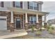 Inviting front porch with stone facade, white columns, and a well-maintained garden at 9505 Cotswood Pl, Gastonia, NC 28056