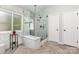 Bright bathroom featuring a marble and glass-enclosed shower and herringbone floors at 9593 Indian Beech Nw Ave, Concord, NC 28027