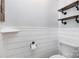 Cozy bathroom features wood floating shelves, toilet, and wainscotting at 9593 Indian Beech Nw Ave, Concord, NC 28027