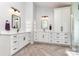 Bright bathroom featuring double vanity, drawers, white cabinets, herringbone floors, and sleek black hardware at 9593 Indian Beech Nw Ave, Concord, NC 28027