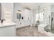 Bright bathroom featuring double vanity, herringbone floors, and a marble and glass-enclosed shower at 9593 Indian Beech Nw Ave, Concord, NC 28027