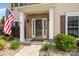 Inviting front porch with brick accents, a security system sign, and landscaping with decorative rock features at 9593 Indian Beech Nw Ave, Concord, NC 28027