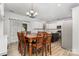 Open-concept kitchen and dining area with white cabinets, island seating, and a wooden dining table at 9593 Indian Beech Nw Ave, Concord, NC 28027